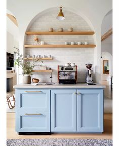 a kitchen with blue cabinets and wooden shelves