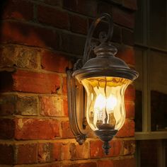 an old fashioned light hanging on the side of a brick building