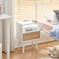 a bedroom with a white bed and wooden flooring, along with a night stand