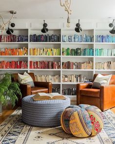 a living room filled with lots of furniture and bookshelves covered in colorful books