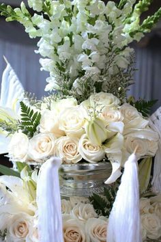 white flowers and greenery in a jar on a table