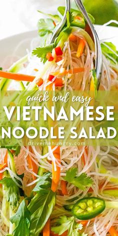 a white plate topped with noodles and veggies next to a green leafy salad