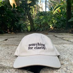 Black embroidered Searching For Clarity on a sand colored dad hat. Strapback. One size fits most. School Merch, Dad Aesthetic, Cap Store, Theatre Inspiration, Hair Covering, Silly Hats, Hat Aesthetic, Embroidery Lessons, Sewing Machine Basics