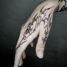 a man's hand with a tattoo design on the middle of his left hand