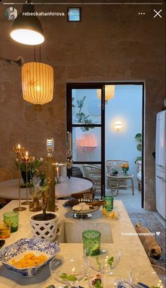 a table with plates and bowls on it in front of a door that leads to an outside patio