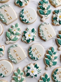 decorated cookies are arranged on a table for the guests to take their place names and date