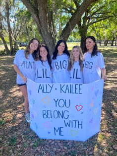 four girls are holding a sign that says, i'll be big ally kalle you belong with me