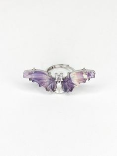 This Rainbow Fluorite Bat Ring gives off stylish, unique vibes. With its adjustable stainless steel design and eye-catching rainbow fluorite carved into bat wings & adorning a bat charm, you'll be sure to make a memorable statement. Bat Ring, Wand Hairstyles, Rainbow Fluorite, Steel Design, Crystal Gifts, Adjustable Ring, Bat Wings, Adjustable Rings, Pink Blue