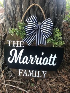 a sign that says the marriatt family with a bow on it sitting next to a tree