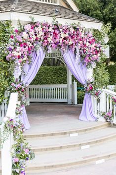 a gazebo decorated with purple and white flowers