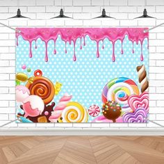 a wall hanging on the side of a brick wall with candy and lollipops