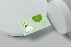 a close up of a business card on a white surface with a green leaf logo