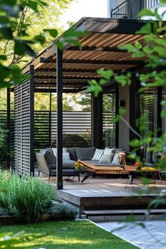 an outdoor living area with couches and tables in the foreground, surrounded by greenery