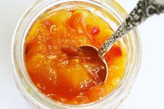 a spoon in a glass jar filled with fruit