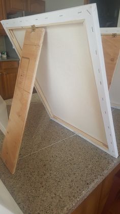 an open door sitting on top of a counter next to a wooden frame with holes in it