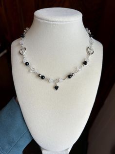 Handmade silver heart beaded necklace with black, silver and white beads. Perfect for a gift for someone special or for yourself! Silver Beaded Necklaces With Heart Beads For Gift, Silver Beaded Necklace With Heart Charm As Gift, Silver Beaded Necklace With Heart Beads For Gift, Handmade Silver Beaded Necklace With Heart Pendant, Sterling Silver Beaded Heart Necklaces, Silver Crystal Necklace With Heart-shaped Beads, Silver Crystal Necklace With Heart And Round Beads, Silver Heart Pendant Beaded Necklaces For Jewelry Making, Silver Heart Pendant For Jewelry Making