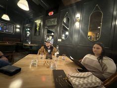 three people sitting at a table in a restaurant