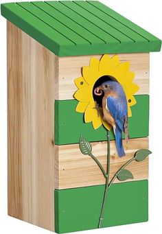 a bird is perched on the side of a wooden birdhouse with a sunflower