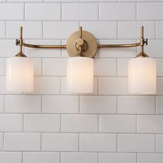 three lights are on the wall in front of a white brick wall and there is no image here to provide a caption for