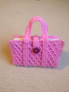 a pink knitted purse sitting on the floor