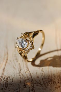 a close up view of a ring with a diamond in it on a wooden surface