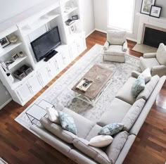 a living room filled with furniture and a flat screen tv on top of a wooden floor