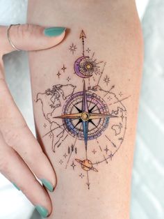 a woman's arm with a compass tattoo on it