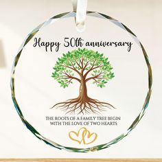 a personalized glass ornament with a tree and two hearts on the bottom