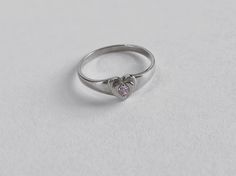 This cute small 14K WHITE GOLD heart signet ring with a center stone is the perfect size for a baby, child, or pinky ring for women. The center stone is a simulated pink or white diamond (Cubic Zirconia). The ring is made of 100% 14K white gold. It's a beautiful ring for a little girl or a gorgeous pinky ring. Ring pictured on a small child's hand and woman's 2 1/2 pinky finger * High Quality Cubic Zirconia Stone * Small sized Ring 🚨Interested in this ring in 14K YELLOW GOLD? Find it here: http White Gold Heart-shaped Birthstone Promise Ring, White Gold Heart-shaped Birthstone Ring, Heart-shaped White Gold Promise Birthstone Ring, White Gold Heart-shaped Promise Birthstone Ring, White Gold Heart Ring With Single Diamond For Gift, White Gold Heart Ring With Birthstone, Personalized White Heart Cut Ring, White Heart Cut Ring With Birthstone, White Heart-shaped Birthstone Ring