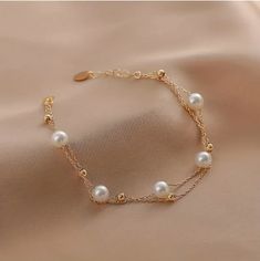 Elevate your accessory game with the Pearl Beaded Bracelet, featuring natural freshwater cultured pearls delicately strung together for an elegant touch. With its 14K gold plated accents and double-layer adjustable design, offering versatility for any occasion. Gift a touch of sophistication to the special girls in your life with this elegant jewelry piece that exudes timeless charm and refinement. Delicate Rose Gold Pearl Bracelet, Gold Adjustable Pearl Bracelet, Pearl Chain Bracelets, Gold Pearl Bracelets With Adjustable Chain, Delicate Pearl Bracelet For Party, Adjustable Pearl Bracelet With Pearl Chain, Adjustable Gold Pearl Bracelet With Delicate Chain, Delicate Adjustable Pearl Bracelet, Rose Gold Pearl Bracelets With Pearl Chain