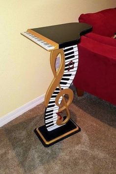 a piano table with musical notes on it and a red couch in the back ground