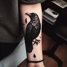 a person with a black crow tattoo on their arm