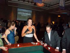 a group of people standing around a table with drinks