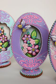 three decorated egg shaped like flowers and butterflies