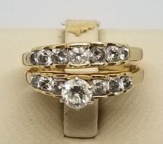 "We do not check prongs for wear or stones for looseness. All items are sold as is-noting that we are a resale shop so everything here had a previous owner! We will include flaws in the description when noted. This is one of the reasons our items are more affordable than new at a jewelry store. Vintage 14K Yellow Gold Ring Set with Est. 1 TCW Diamonds, Size 7.25. Engagement band with 7 diamonds, Wedding band with a ¼ Carat main stone and 3 other diamonds on each side. Stamped A51 14K on both ban Classic Rings With Vs Clarity For Marriage, Classic Bridal Sets With Diamond Accents For Anniversary, Classic Bridal Sets With Vs Clarity Round Cut, Vs Clarity Round Cut Bridal Set For Anniversary, Diamond Ring For Marriage With Channel Set, Channel Set Diamond Ring For Marriage, Marriage Diamond Ring Channel Set, Classic Bridal Sets With Center Stone For Anniversary, Marriage Channel Set Diamond Ring