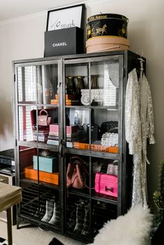 a closet filled with lots of purses and handbags next to a wall mounted shelf