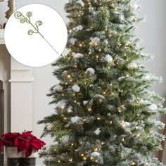 a white christmas tree with lights and ornaments on it, next to a potted plant