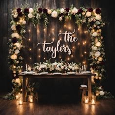 a table with candles and flowers on it that says the taylors in white letters