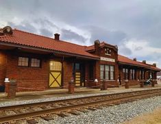 an old train station is shown on the tracks