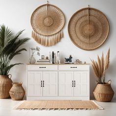 two woven baskets are hanging on the wall above a white cabinet with drawers and doors