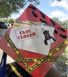 a graduation cap that has been decorated with stickers and tape around it, which says case closed