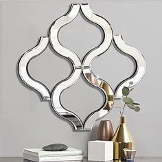 a mirror that is sitting on top of a table next to a vase with flowers in it