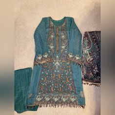 This Is A Brand New Pakistani Women’s Shalwar Kameez Dress In Size Medium Readymade. Designer Eden Robe From Pakistan. Beautiful Blue/Green And Bronze Color Combination With Full Embroidery On The Shirt. Fancy Tassels On Sleeves And Shirt. Comes With Chiffon Dupatta And Trouser. Perfect For Eid Or Party Wear. If You Have Any Questions Or Need Exact Measurements, Feel Free To Message Me. Chest 20 Inches One Side Green Long Sleeve Salwar Kameez For Party, Long Sleeve Lawn Suit For Diwali Party, Unstitched Jamawar Kurta For Party, Transitional Unstitched Lawn Suit For Party, Traditional Lawn Suit For Eid Party, Chanderi Lawn Suit For Eid Party, Unstitched Shantoon Kurta For Party, Traditional Chikankari Lawn Suit For Party, Fitted Shantoon Salwar Kameez For Party