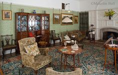 a living room filled with furniture and a fire place in the middle of a room