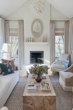 a living room with couches, chairs and a fire place in the middle of it