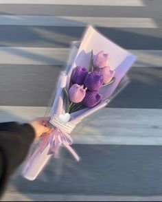 a person holding a bouquet of flowers on the street