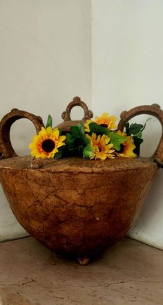 an old wooden bowl with sunflowers in it