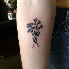 a small flower tattoo on the arm