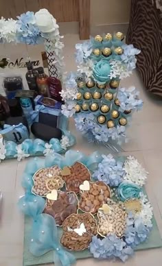 a table topped with lots of blue and white flowers on top of a counter covered in chocolates