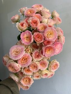 a bouquet of pink and white roses in someone's hand with the flowers still blooming